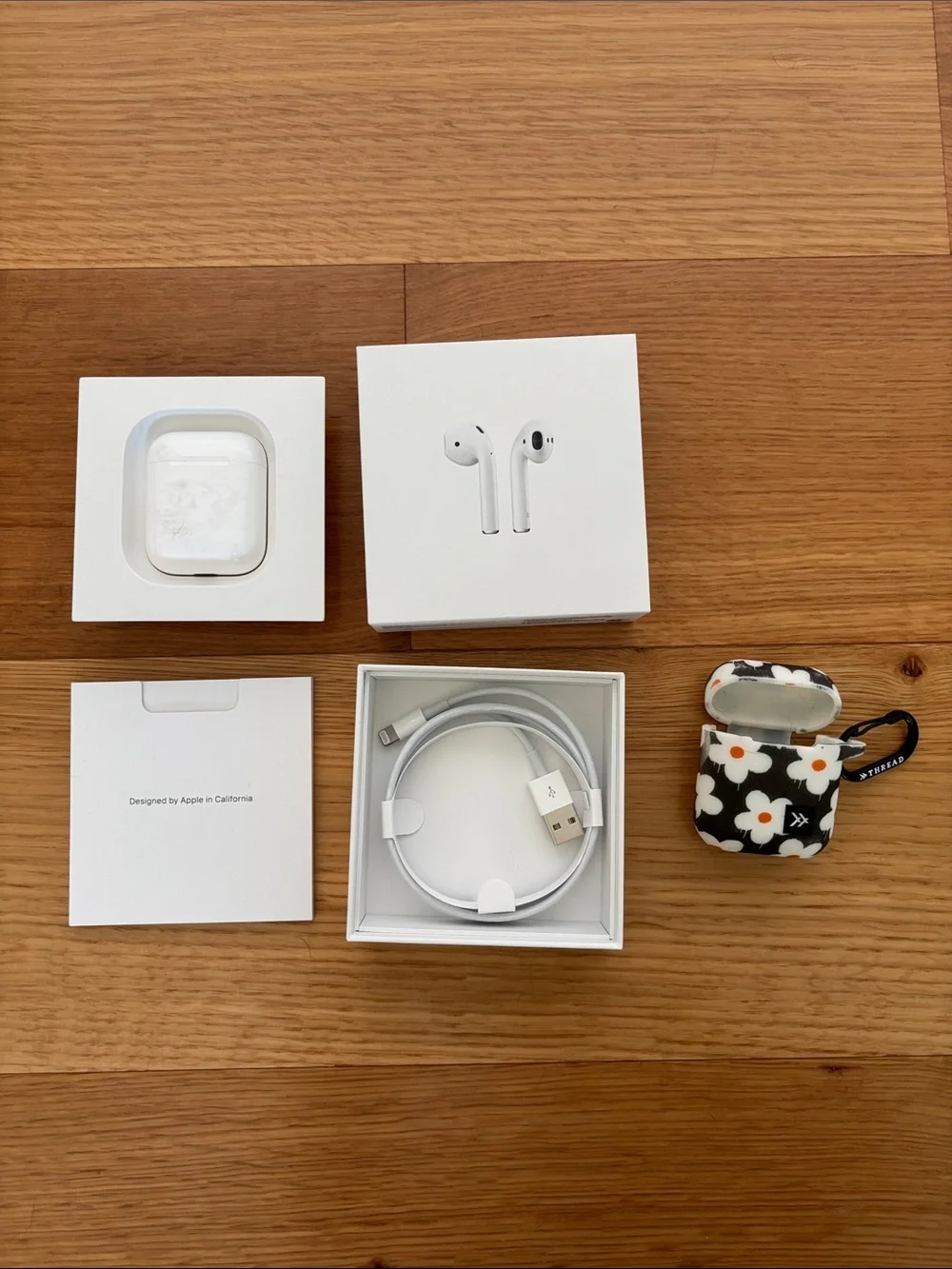 Apple AirPods (2nd gen) with charging case, charging cable, and ThredUp case